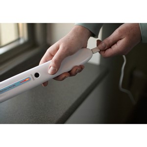 A gloved hand holding the Handheld UV Wand